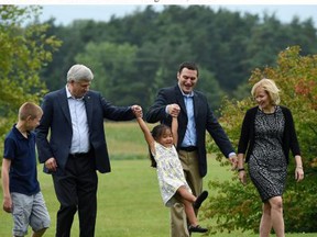 Conservative  Leader Stephen Harper swings Beatrice as her father Conservative candidate Jeff Watson  holds her other hand during a campaign  stop in Newmarket , Ontario on Thursday, August 20, 2015