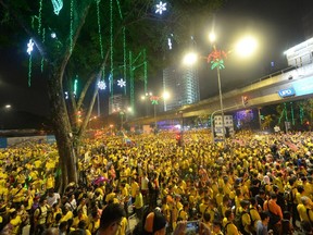 Protesters sit along a main road in Kuala Lumpur during a rally organised by pro-democracy group "Bersih" (Clean), Malaysia, Saturday, Aug. 29, 2015. Tens of thousands of Malaysians wearing yellow T-shirts and blowing horns defiantly held a major rally in the capital Saturday to demand the resignation of embattled Prime Minister Najib Razak.