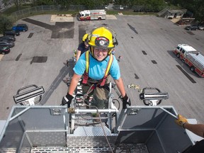 Rachel Boushell, 19, climbs to the top of a fire engine ladder as young women between the ages of 15 and 19 enjoy training in some of the duties of an Ottawa firefighter as they participate in the week-long Camp FFIT (Female Firefighters in Training). Assignment - 121385 Photo taken at 14:20 on August 18. (Wayne Cuddington/ Ottawa Citizen)