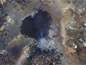Smoke rises from debris near a crater that was at the center of a series of explosions in northeastern China's Tianjin municipality Saturday, Aug. 15, 2015, as seen from an aerial view. New explosions and fires rocked the Chinese port city of Tianjin on Saturday, as one survivor was pulled out and authorities ordered evacuations to clean up chemical contamination more than two days after a fire and a series of blasts set off the disaster.