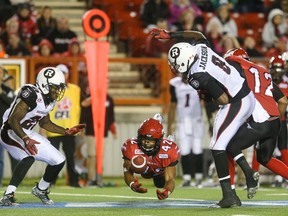 Calgary Stampeders running back Keith Toston, centre, leaps to catch a Ottawa Redblacks fumble at McMahon Stadium in Calgary on Saturday, Aug. 15, 2015.