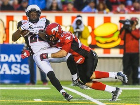 Ottawa Redblacks running back Chevon Walker, left, is taken out by Calgary Stampeder running back William Langlais at McMahon Stadium in Calgary on Saturday, Aug. 15, 2015. The Calgary Stampeders led the Ottawa Redblacks, 31-3, at the half in regular season CFL play.