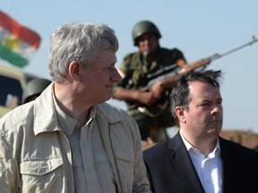 A Kurdish soldier sits in the background as Prime Minister Stephen Harper and Minister of Defence Jason Kenney visit members of the Advise and Assist mission, approximately 6 km from active ISIL fighting positions, 40 km west of Erbil, Iraq, on Saturday, May 2, 2015.