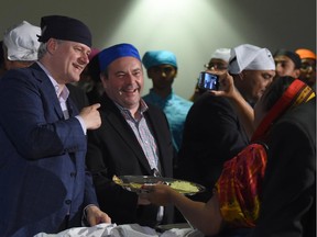 Conservative leader Stephen Harper and conservative candidate Jason Kenney serve food at Gursikh Sabha Canada temple during a campaign stop at in Scarboroough, Ontario on Wednesday, August 26, 2015.