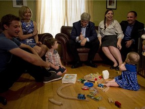 Conservative leader Stephen Harper gives the thumbs up to Lysander Konstantinakos, third from left, who recited the alphabet as his mother Kirsten Konstantinakos and father Damian Konstantinakos, Laureen Harper, second from left, and Ben Harper, left, look on during a campaign stop at a home in Ottawa on Monday.
