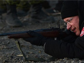 Prime Minister Stephen Harper shoots a .303 Lee Enfield rifle while taking part in demonstration from Canadian Rangers near the Artic community of Gjoa Haven, Nunavut on Tuesday, August 20, 2013.