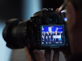 A reporter films Conservative leader Stephen Harper as he delivers a statement during a campaign stop in Quebec City on Tuesday, August 25, 2015.