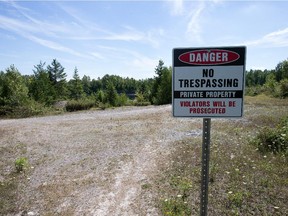 Signs forbidding access to the quarry are set in concrete. Two sets of earlier signs were removed by trespassers, area residents say.