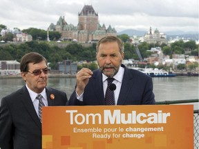 New Democratic Party Leader Tom Mulcair speaks at a lectern bearing his party's slogan.