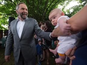 NDP Leader Tom Mulcair, left, greets 11-week-old Leonie Mendelsohn and her mom Ellen Friedrichs as he arrives for a campaign stop in the backyard of a home in Vancouver, B.C., on Thursday, August 20, 2015. A federal election will be held October 19.