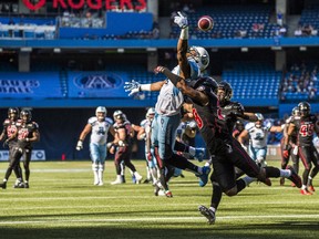 Toronto Argonauts Vidal Hazelton can't catch a ball with coverage from Ottawa RedBlacks Jacques Washington during the first half of CFL football action in Toronto, Sunday August 23, 2015.