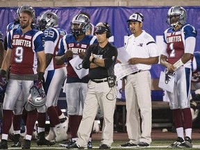 Montreal Alouettes' general manager and head coach Jim Popp, centre, looks on from the sidelines alongside quarterback coach Anthony Calvillo during first half CFL football action against the BC Lions in Montreal on September 3, 2015. The Montreal Alouettes shook up their coaching staff once again on Saturday by firing offensive co-ordinator Turk Schonert. Anthony Calvillo and Ryan Dinwiddie have been promoted and will act as co-offensive coordinators