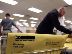 An Elections Canada worker assembles election materials packages in Ottawa Thursday, November 20, 2014 in preparation for the 42nd General Election.