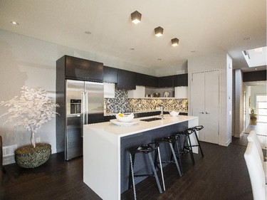 The clean lines continue in the kitchen of the Parkway, with dark cabinets and light waterfall counter on the island.