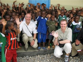 Barry Finlay and his son, Chris, pose with children at a preschool in Mwanza, Tanzania, in 2009.