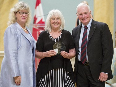 Béatrice Gagné Plourde from Statistics Canada, center, receives the Public Service Award of Excellence for Outstanding Career from Janice Charette, clerk of the privy council, left, and David Johnston, Governor General of Canada, right, at Rideau Hall Wednesday September 16, 2015. (Darren Brown/Ottawa Citizen) - Assignment 121627