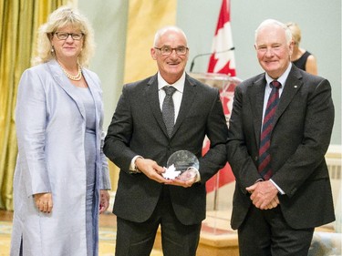Benoit Simard from the National Research Council Canada, center, receives the Public Service Award of Excellence for Scientific Contribution on behalf of the NRC's Nanotube Manufacturing Team from Janice Charette, clerk of the privy council, left, and David Johnston, Governor General of Canada, right, at Rideau Hall Wednesday September 16, 2015. (Darren Brown/Ottawa Citizen) - Assignment 121627