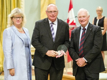 Bruce Moore of Public Safety Canada, center, receives the Public Service Award of Excellence for Excellence in Citizen-Focused Service Delivery from Janice Charette, clerk of the privy council, left, and David Johnston, Governor General of Canada, right, at Rideau Hall Wednesday September 16, 2015. (Darren Brown/Ottawa Citizen) - Assignment 121627
