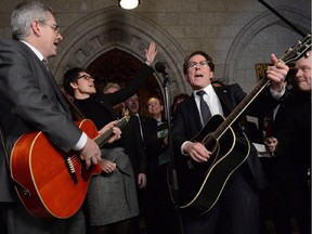 NDP MPs Charlie Angus, Megan Leslie and Andrew Cash are joined by fellow NDP MPs performing a Stompin' Tom song in the foyer of the House of Commons on Parliament Hill in Ottawa on Thursday March 7, 2013.