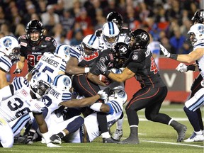 The Redblacks' Chevon Walker tries to push the ball past a wall of Toronto Argonauts during the first half in Ottawa on Saturday, Sept. 26, 2015.