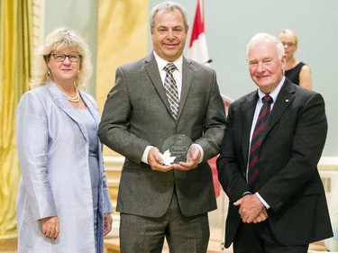 Christopher Seidl of Canadian Radio-television and Telecommunications Commission receives the Public Service Award of Excellence for Excellence in Policy on behalf of the Modernizing Northern Telecommunications Team from Janice Charette, clerk of the privy council, left, and David Johnston, Governor General of Canada, right, at Rideau Hall Wednesday September 16, 2015. (Darren Brown/Ottawa Citizen) - Assignment 121627