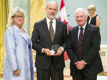 Derek C.G. Muir from Environment Canada, center, receives the Public Service Award of Excellence for Outstanding Career from Janice Charette, clerk of the privy council, left, and David Johnston, Governor General of Canada, right, at Rideau Hall Wednesday September 16, 2015. (Darren Brown/Ottawa Citizen) - Assignment 121627