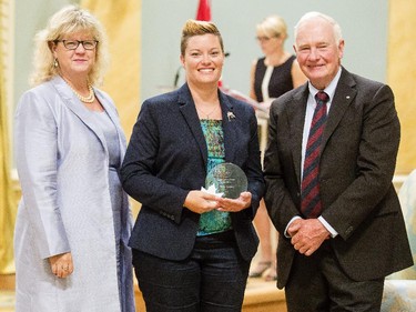 Devon Bartley of Dept. of Justice Canada, center, receives the Public Service Award of Excellence for Blueprint 2020 from Janice Charette, clerk of the privy council, left, and David Johnston, Governor General of Canada, right, at Rideau Hall Wednesday September 16, 2015. (Darren Brown/Ottawa Citizen) - Assignment 121627