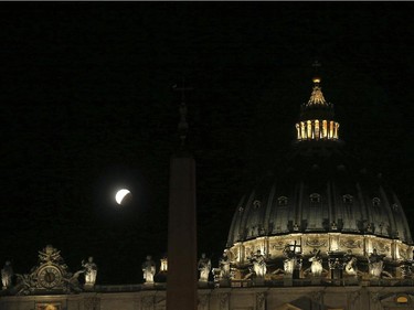 Earth's shadow obscures part of a so-called Supermoon during a total lunar eclipse above St. Peter's Basilica, at the Vatican, Monday, Sept. 28, 2015. Supermoon, or perigee moon, is the name given when the full or new moon comes closest to the Earth making it appear bigger.