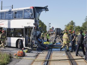 September 18, 2013 -- The front of the bus is barely distinguishable while firefighters and police search at the scene of a horrific crash between an OC Transpo double decker bus and a VIA train near the Fallowfield station in Barrhaven,