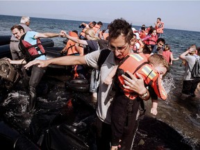 Refugees and migrants arrive on Eftalou beach, west of the port of Mytilene, on the Greek island of Lesbos after crossing the Aegean sea from Turkey on September 21, 2015. Europe's migrant crisis took centre-stage at the UN human rights council, as European states said the need to end the conflict in Syria was at an all-time high.