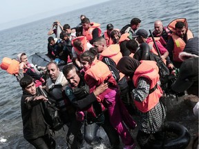 Syrian refugees land on the shores of the Greek island Lesbos in an inflatable dingy across the Aegean Sea from  Turkey on September 3, 2015. More than 230,000 refugees and migrants have arrived in Greece by sea this year, a huge rise from 17,500 in the same period in 2014, deputy shipping minister Nikos Zois said.