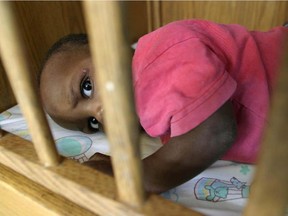 A child awaits adoption at a Haitian orphanage. While the Conservatives have reduced foreign aid funding, the Liberals and NDP say they would restore ties with traditional aid groups.