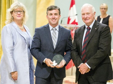 Jeff Labonte of Natural Resources Canada receives the Public Service Award of Excellence for Excellence in Policy on behalf of the team involved in Advancing World Class Pipeline, Offshore and Nuclear Safety and Security from Janice Charette, clerk of the privy council, left, and David Johnston, Governor General of Canada, right, at Rideau Hall Wednesday September 16, 2015. (Darren Brown/Ottawa Citizen) - Assignment 121627