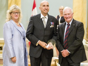 Jeffrey de Fourestier from National Defence receives the Public Service Award of Excellence for Excellence in Citizen-Focused Service Delivery from Janice Charette, clerk of the privy council, left, and David Johnston, Governor General of Canada, right, at Rideau Hall Wednesday September 16, 2015. (Darren Brown/Ottawa Citizen) - Assignment 121627