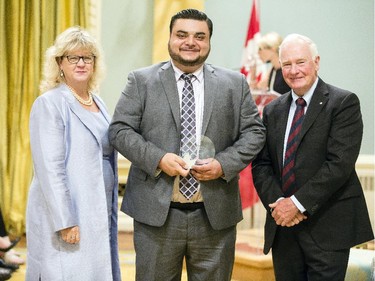 Jimmy Ammoun of Employment and Social Development Canada, Labour Program, center, receives the Public Service Award of Excellence for Blueprint 2020 from Janice Charette, clerk of the privy council, left, and David Johnston, Governor General of Canada, right, at Rideau Hall Wednesday September 16, 2015. (Darren Brown/Ottawa Citizen) - Assignment 121627