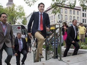 Liberal Leader Justin Trudeau marches up the stairs of Quebec City Hall to meet with Quebec City Mayor Regis Labeaume  Wednesday.