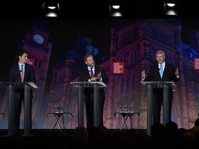 Liberal leader Justin Trudeau, left, NDP leader Tom Mulcair and Conservative leader Stephen Harper take part in the Globe and Mail hosted  leaders' debate as moderator David Walmsley looks on  Thursday, September 17, 2015  in Calgary