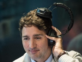 Liberal leader Justin Trudeau listens to a sound clip during a live radio interview Wednesday, September 2, 2015 in Quebec City.