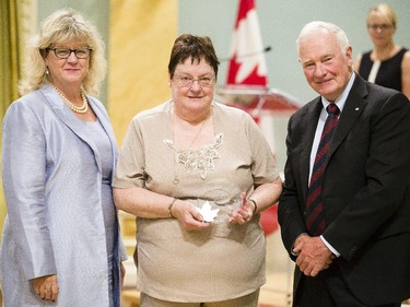 Kathryn Horrelt of Canada Revenue Agency receives the Public Service Award of Excellence for Employee Equity and Diversity from Janice Charette, clerk of the privy council, left, and David Johnston, Governor General of Canada, right, at Rideau Hall Wednesday September 16, 2015. (Darren Brown/Ottawa Citizen) - Assignment 121627