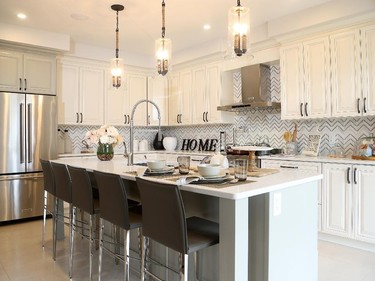 In place of an eat-in kitchen, the island in the Killarney has been extended instead for easy entertaining and seats five comfortably. The gourmet kitchen includes quartz counters, marble backsplash and cabinets in white and soft grey.