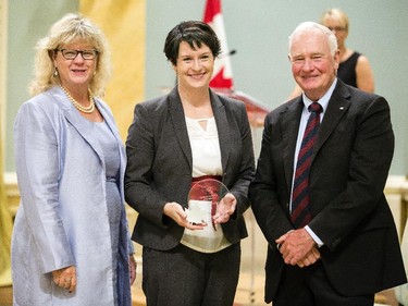 Lauren Hunter from Natural Resources Canada, center, receives the Public Service Award of Excellence for Blueprint 2020 from Janice Charette, clerk of the privy council, left, and David Johnston, Governor General of Canada, right, at Rideau Hall Wednesday September 16, 2015. (Darren Brown/Ottawa Citizen) - Assignment 121627