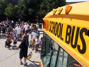 Local Input~ OTTAWA, ON: AUG. 23, 2009 - Children and parents line-up outside Sir Guy Carleton High School during School Bus Awareness Day, Sunday, August 23, 2009 in Ottawa. The event is geared primarily for children (and parents) new to school bus transportation. (photo by MIKE CARROCCETTO /  Ottawa Citizen)   (for CITY / WEB story by CHIANELLO) NEG# 96345