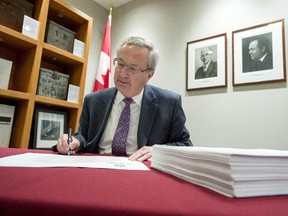 Chief Electoral Officer Marc Mayrand signs the writs of election for the 42nd general election during a photo op in Gatineau, Que., on Friday, August 14, 2015. There are a total of 338 writs, one for each of the electoral districts.