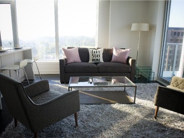 Nine-foot ceilings and windows on two sides combine with a glass-topped coffee table and a set of clear nesting tables to create a sense of spaciousness in the two-bedroom unit.