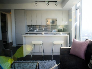 The kitchen of the two-bedroom, like all units, features quartz counters. Designer Brian Gluckstein has gone with grey and granite tones for the cabinetry and a larger island/eating area.