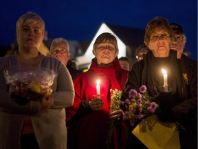 Mourners hold a candlelight vigil in remembrance of Carol Culleton, Anastasia Kuzyk and Natalie Warmerdam in Wilno on Friday, Sept. 25, 2015.
