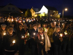 Mourners hold a candlelit vigil in remembrance of Carol Culleton, Anastasia Kuzyk and Natalie Warmardam in Wilno on Friday, Sept. 25, 2015.