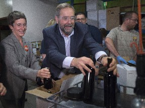NDP Leader Tom Mulcair tries his hand at a bottling line during a federal election campaign stop at Summerhill Winery in Kelowna, B.C. Tuesday, Sept, 1 2015.