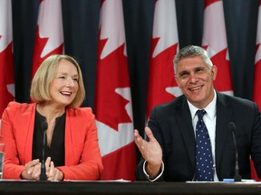 NDP industry critic Peggy Nash, left, shares a laugh with fellow candidate Andrew Thomson about Finance Minister Joe Oliver during a news conference in Ottawa, Tuesday September 1, 2015.