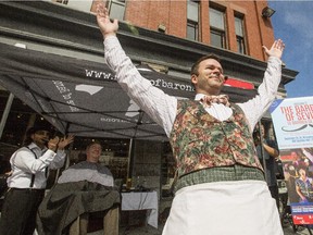 Opera Lyra's Joshua Hopkins serenades spectators while House of Barons barbers give Ottawa Mayor Jim Watson and Jonathan Pitre a trim in the background during a promotional event in the Byward Market Thursday September 10, 2015 for Opera Lyra's The Barber of Seville, which runs from Saturday September 26 to Saturday October 3 at the NAC.